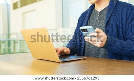 Man using laptop and smartphone
