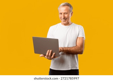 Man Using Laptop and Smiling in Front of Yellow Background During Daytime