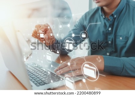Man using laptop and touching on internet cloud document storage technology icon virtual screen with document management system, icons on virtual screens.technology innovation concept.