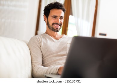 Man Using A Laptop While Sitting On The Couch