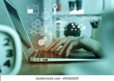 Man Using Laptop At Workplace With Digital Business Screen. Accounting And Finance Concept. Double Exposure 