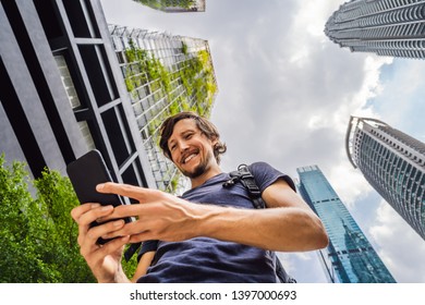 man using map app on smartphone on the background of skyscrapers