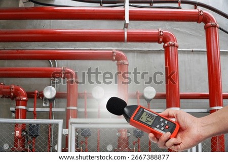 man is using a measuring sound level of a fire extinguishing system.Noise pollution prevention concept