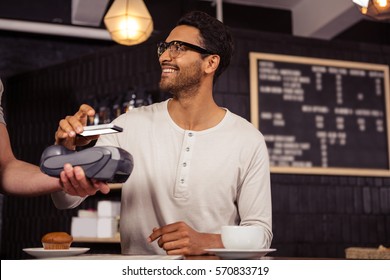 Man using mobile payment in a coffee shop