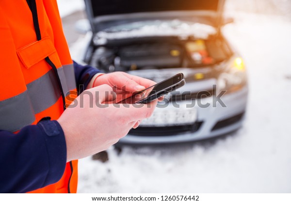 Man using mobile phone call emergency car service,\
broken car on the road
