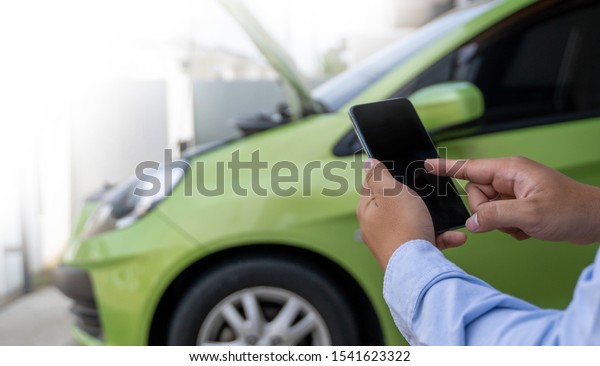 man Using a mobile\
phone call to  assistance Help with a broken down car assist stop\
car roadside breakdown