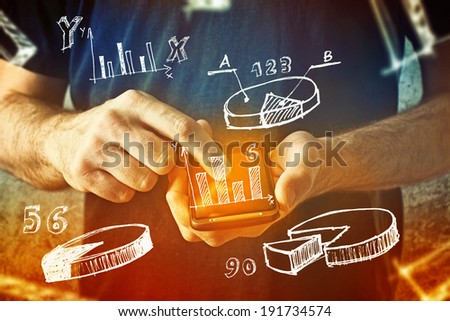 Man using mobile phone with drawings of charts and other infographics in note pad. Close up image with selective focus. Business situation.