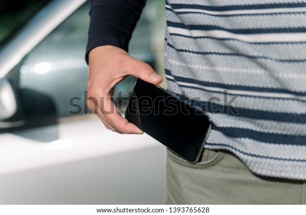 Man\
using a mobile phone on car background, closeup image of social\
media, communication technology and busy\
lifestyle
