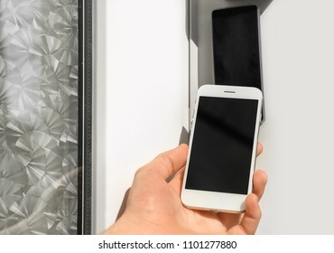 Man Using Mobile Phone For Opening Door Outdoors