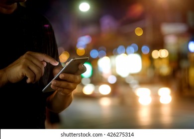 Man Using Mobile Phone In The Street, Night Light Bokeh Background