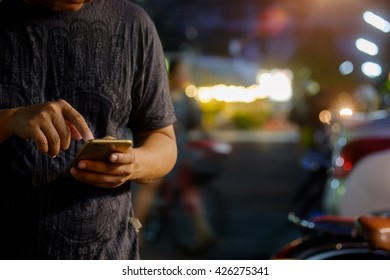 Man Using Mobile Phone In The Street, Night Light Bokeh Background