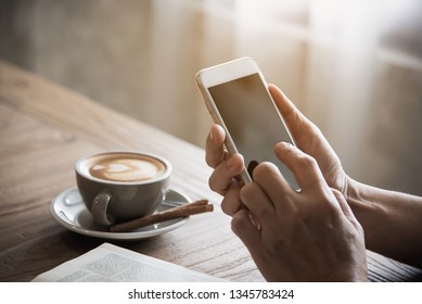 Man using mobile phone while drinking coffee and reading book in coffee shop - modern life style people in coffee shop concept - Powered by Shutterstock