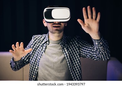 Man using modern 3D vr glasses indoors. Student playing using VR glasses. Handsome man wearing virtual reality headset. Augmented Reality