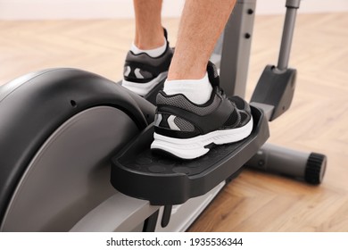 Man Using Modern Elliptical Machine Indoors, Closeup