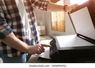 Man using modern multifunction printer in office, closeup