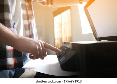 Man using modern multifunction printer in office, closeup