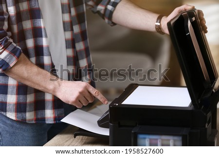 Man using modern multifunction printer in office, closeup