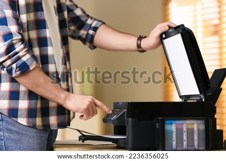 Man using modern multifunction printer in office, closeup