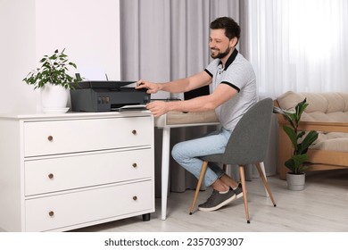 Man using modern printer at workplace indoors