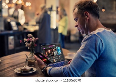 Man using modern tech while sitting in cafe - Shutterstock ID 1118068070