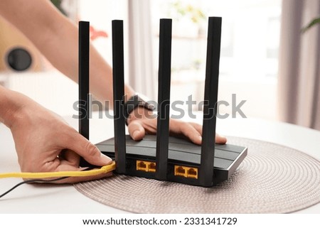 Man using modern wireless router, high speed internet