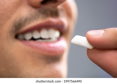 Man Using Nicotine Gum To Quit Smoking. Nicotine Replacement Therapy