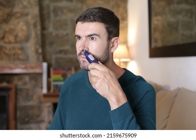 Man Using Nose Hair Trimmer At Home