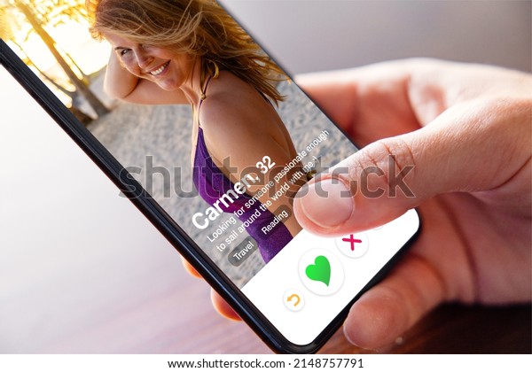 Man using online dating app on phone and viewing
someone's profile photo