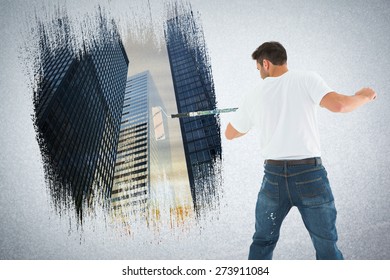 Man using paint roller on white background against low angle view of skyscrapers