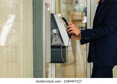 Man Using Payphone At The Train Station