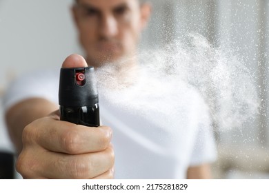 Man using pepper spray at home, focus on hand