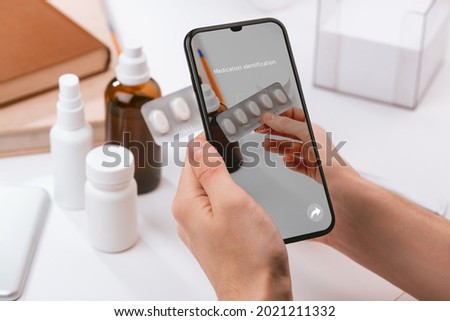 Man using a phone app to recognize unknown pills and to learn more information about them. Modern technologies and medicine.