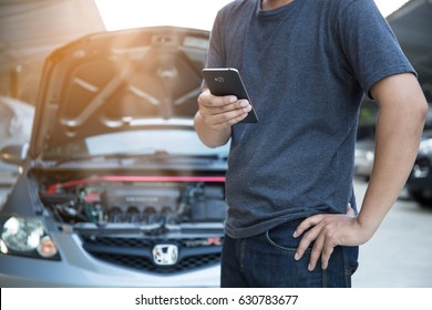 The Man Is Using The Phone In Asking For Help When His Car Is Broken.