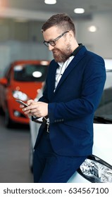 Man Using Phone In Car Dealership.