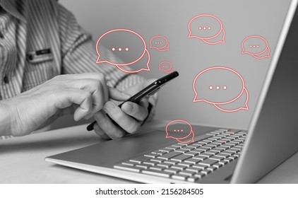 Man using phone for responding to negative feedback and reviews, bad comments, customers claims and complaints. Male sitting at table with laptop. Black and white. High quality photo - Shutterstock ID 2156284505