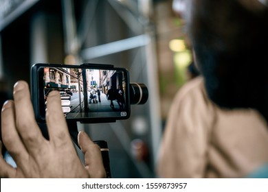 Man Using Phone With Stabilizer And Taking Pictures And Live Video In New York City. Vlog, Video Blogging, Street Photography Concept. 