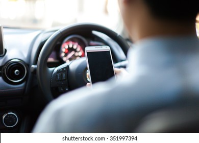 man using phone while driving the car (selective focus) - transportation and vehicle concept - Shutterstock ID 351997394