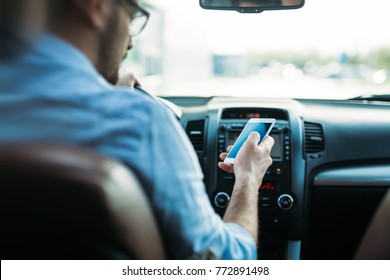 man using phone while driving the car - Shutterstock ID 772891498
