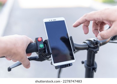 Man using a phone while riding a bike, image of dangerous bend as background. copy space