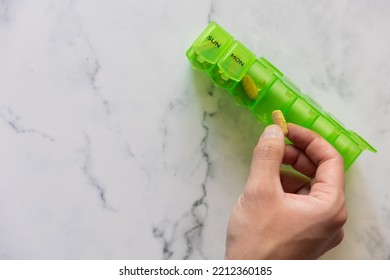 Man Using A Pill Box Organizer