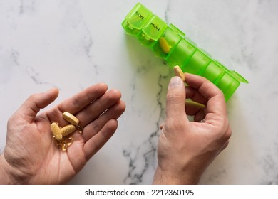 Man Using A Pill Box Organizer