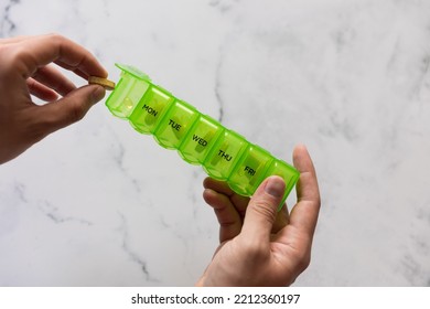 Man Using A Pill Box Organizer