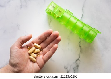 Man Using A Pill Box Organizer