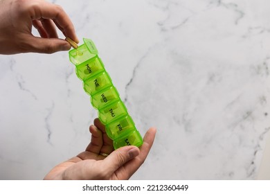 Man Using A Pill Box Organizer