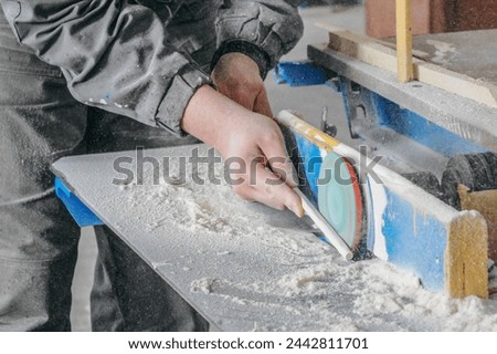 A man is using a power tool to cut wood. Concept of focus and determination as the man works on his project