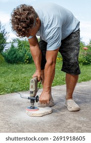 A man is using a power tool to grind a stone. Concept of hard work and determination as the man focuses on his task