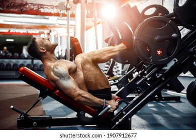 Man Using A Press Machine In A Fitness Club. Strong man doing an exercise on its feet in the simulator. Side view