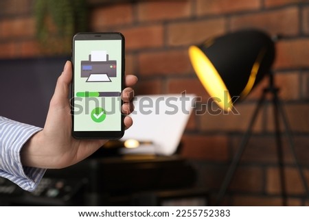 Man using printer management application on mobile phone indoors, closeup and space for text