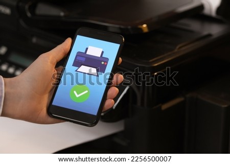 Man using printer management application on mobile phone indoors, closeup and space for text