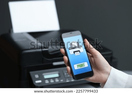 Man using printer management application on mobile phone indoors, closeup and space for text